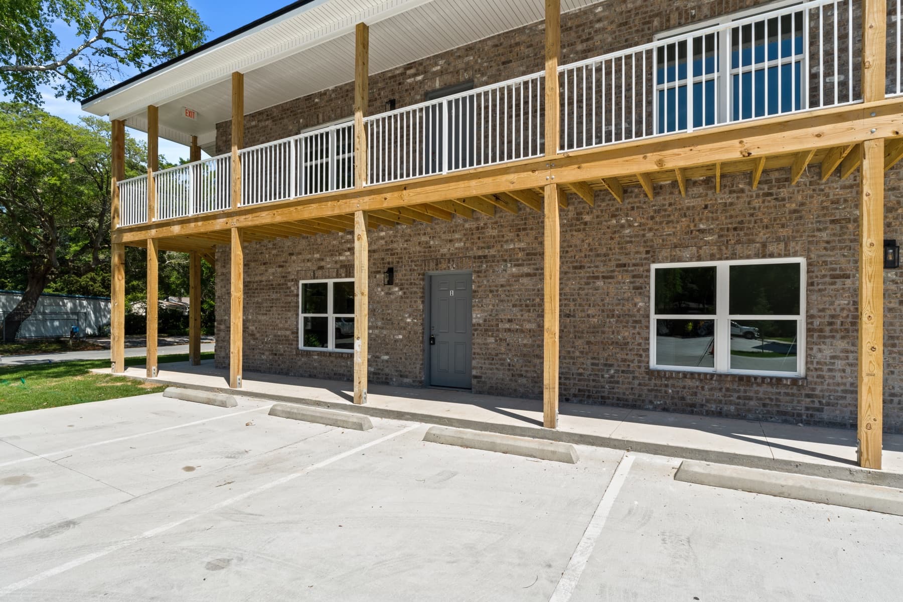 Covered ground-floor walkway and second-story balcony framing on a new brick apartment building built by Whitrock Associates, Northwest Florida