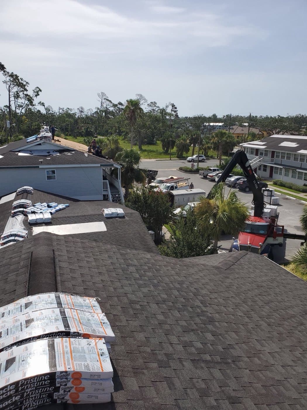Crane loading roofing materials on a Panama City, FL building by Whitrock Associates