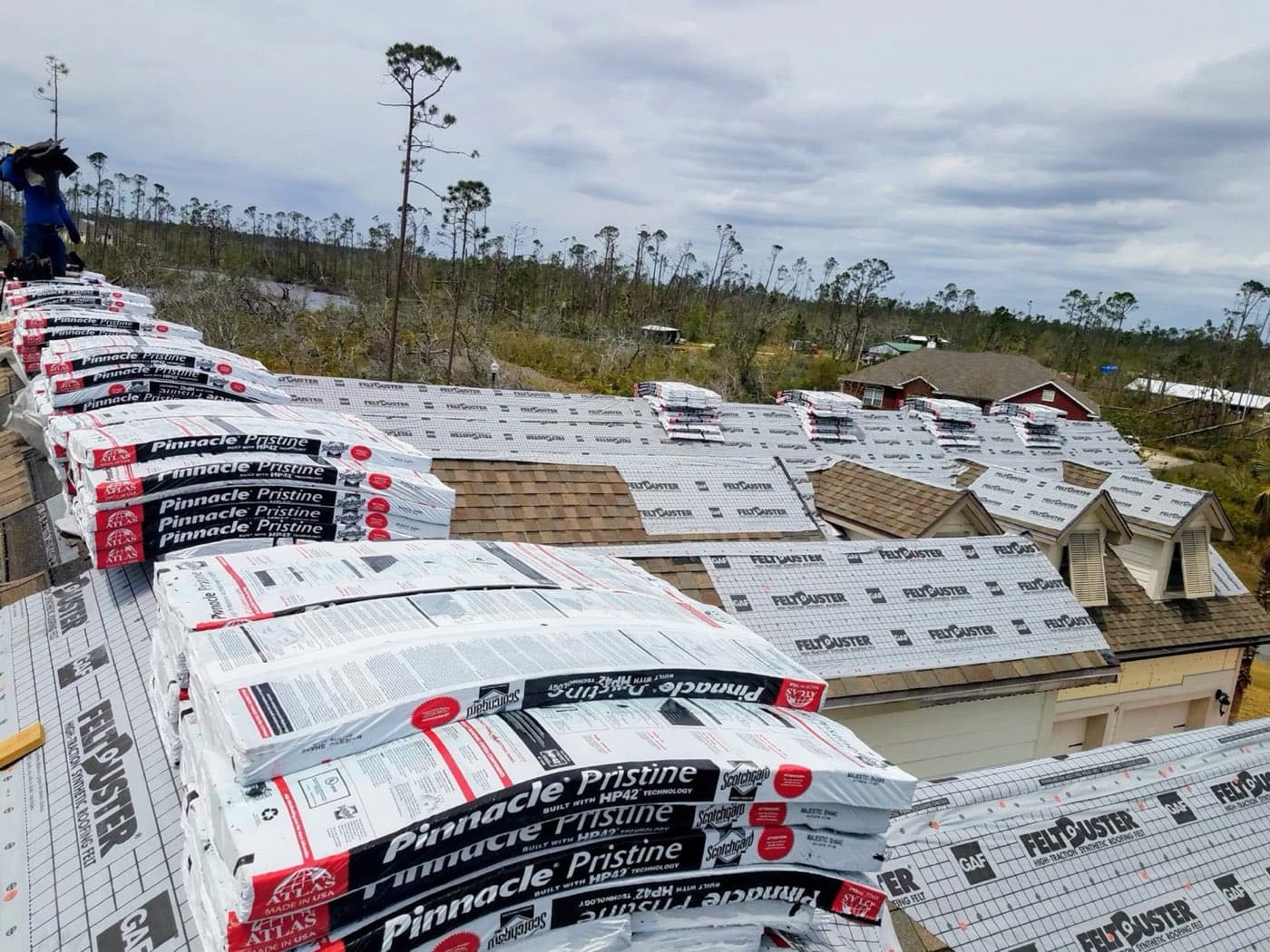 Peel-and-stick underlayment and shingle bundles staged during a roof installation, Northwest Florida